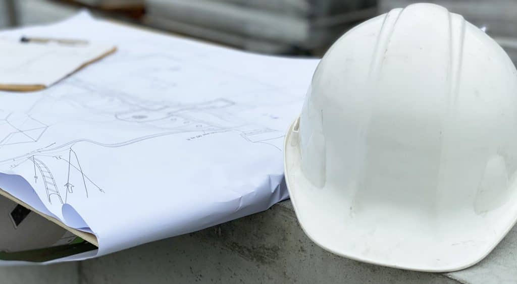 Hard hat and project blueprints on job site